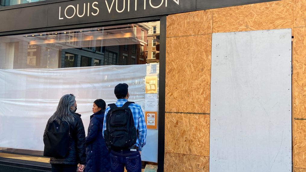FILE - Union Square visitors look at damage to the Louis Vuitton store on Nov. 21, 2021, after looters ransacked businesses in San Francisco. (Danielle Echeverria/San Francisco Chronicle via AP, File)
